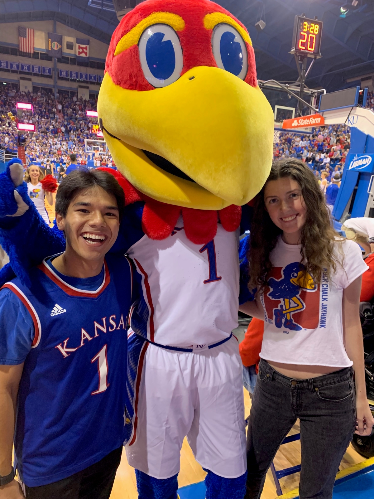 KU students posing with the Jayhawk mascot in Allen Fieldhouse.