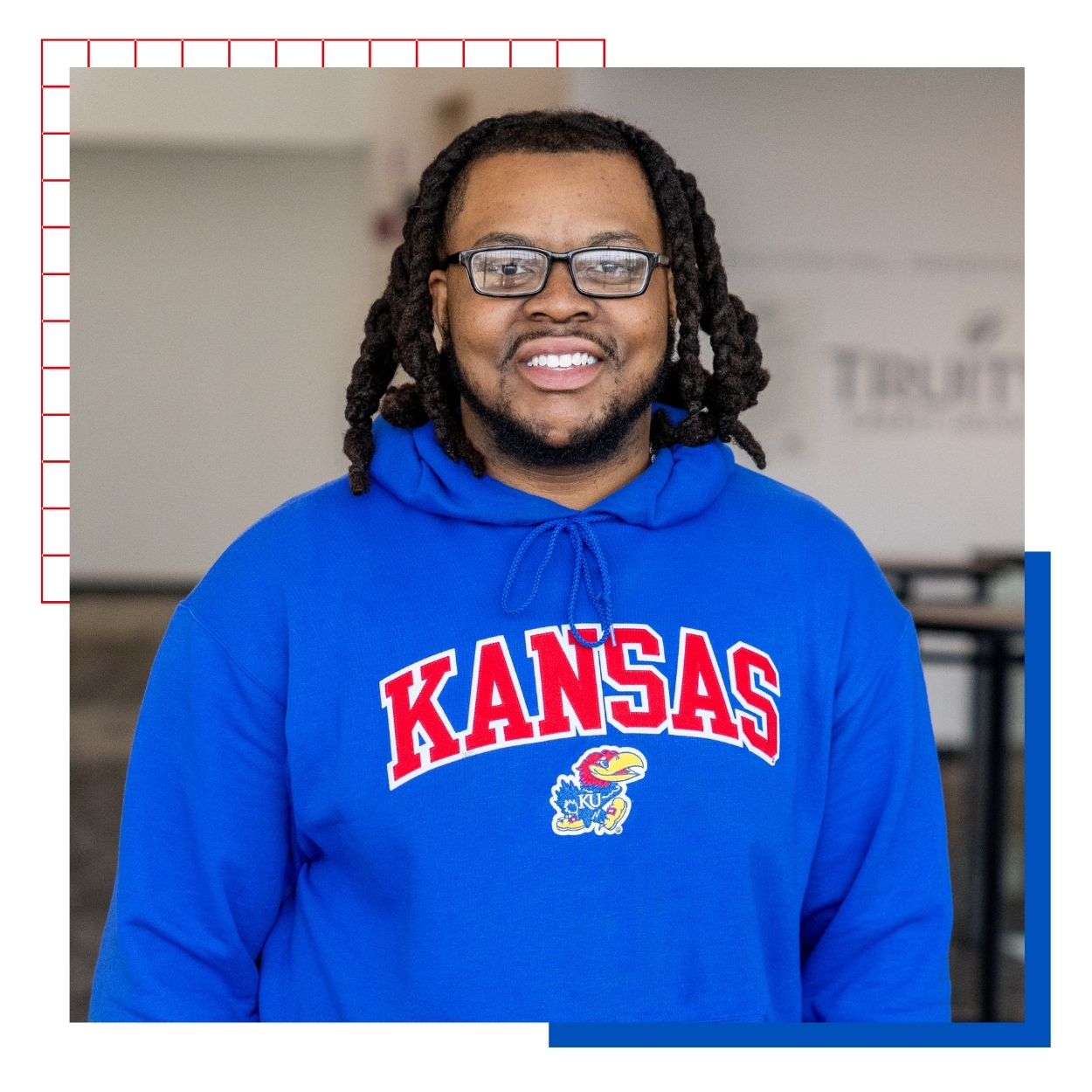 University of Kansas transfer student Jai Moore poses for a portrait in a blue KU hoodie. 