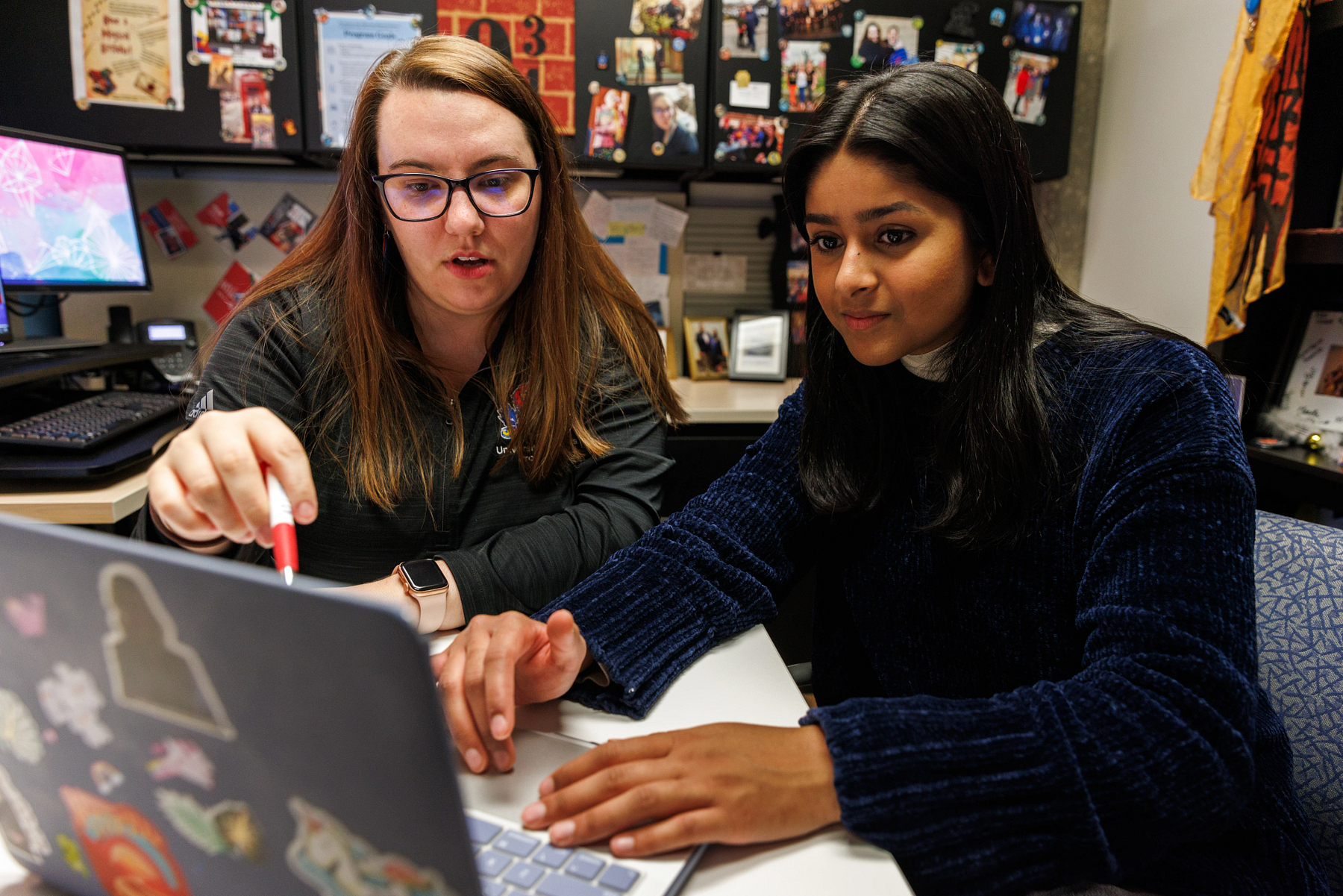 A University of Kansas student and her advisor look at a laptop screen to help determine how long it will take to get a bachelor's degree.