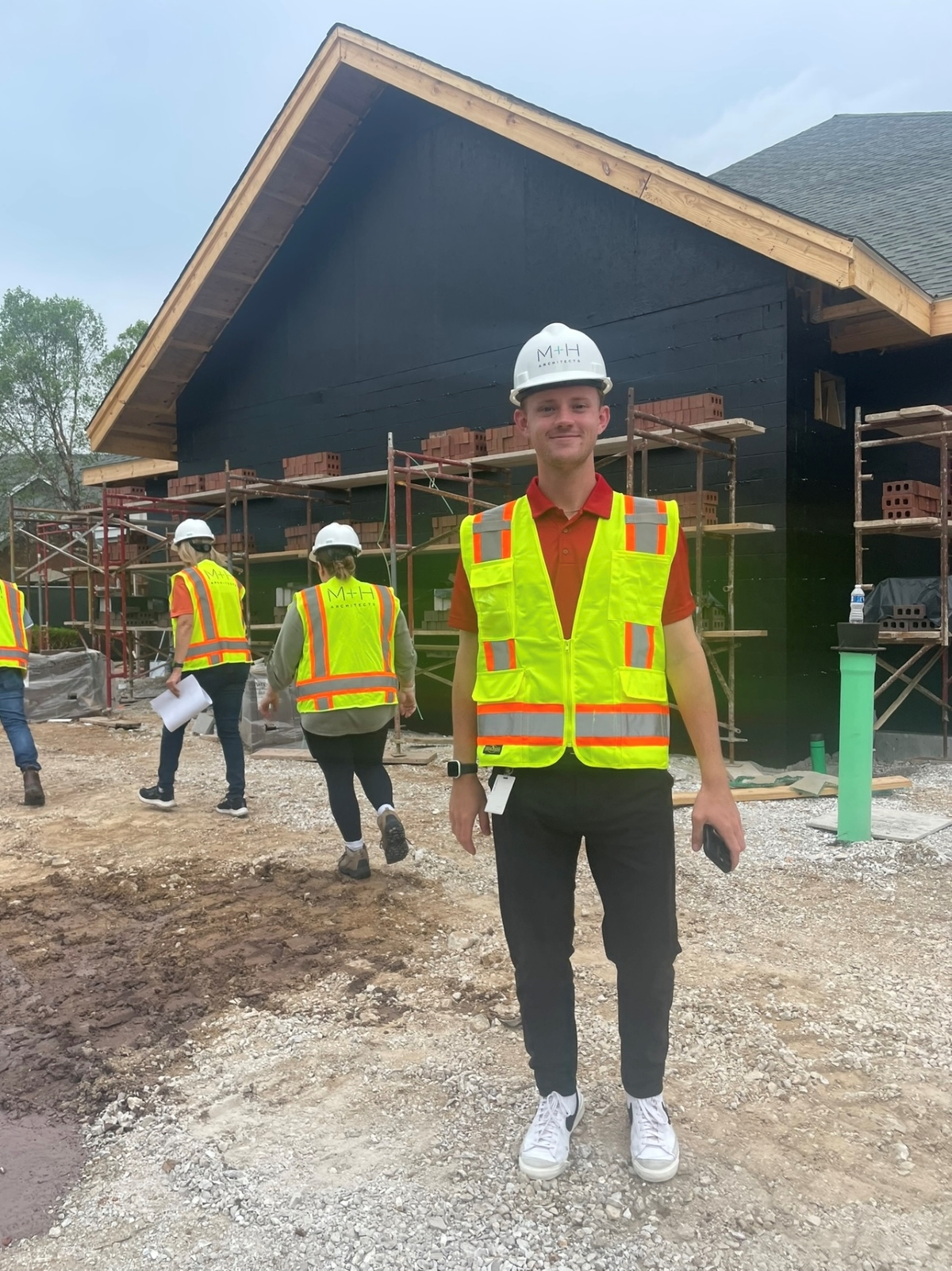 University of Kansas architecture student Adam Cory in a neon vest in from of a build site during his internship with M+H Architects on a tour of a construction site.