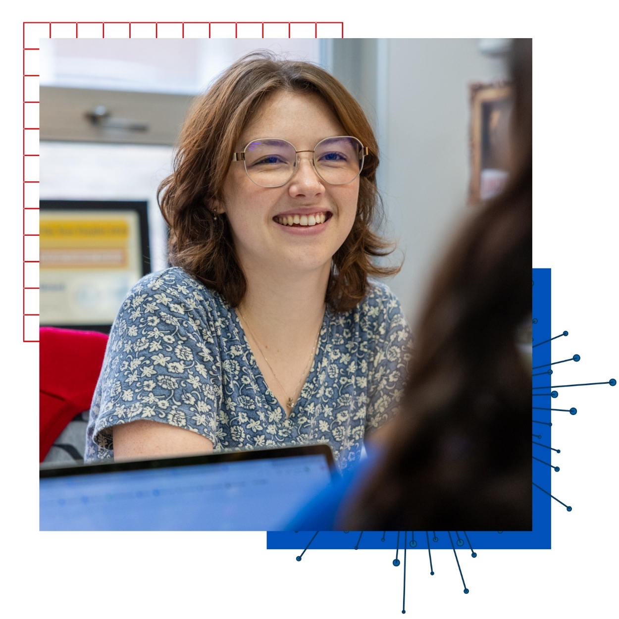 KU Honors Engineering advisor Emilee Girard consults with a student across her desk.