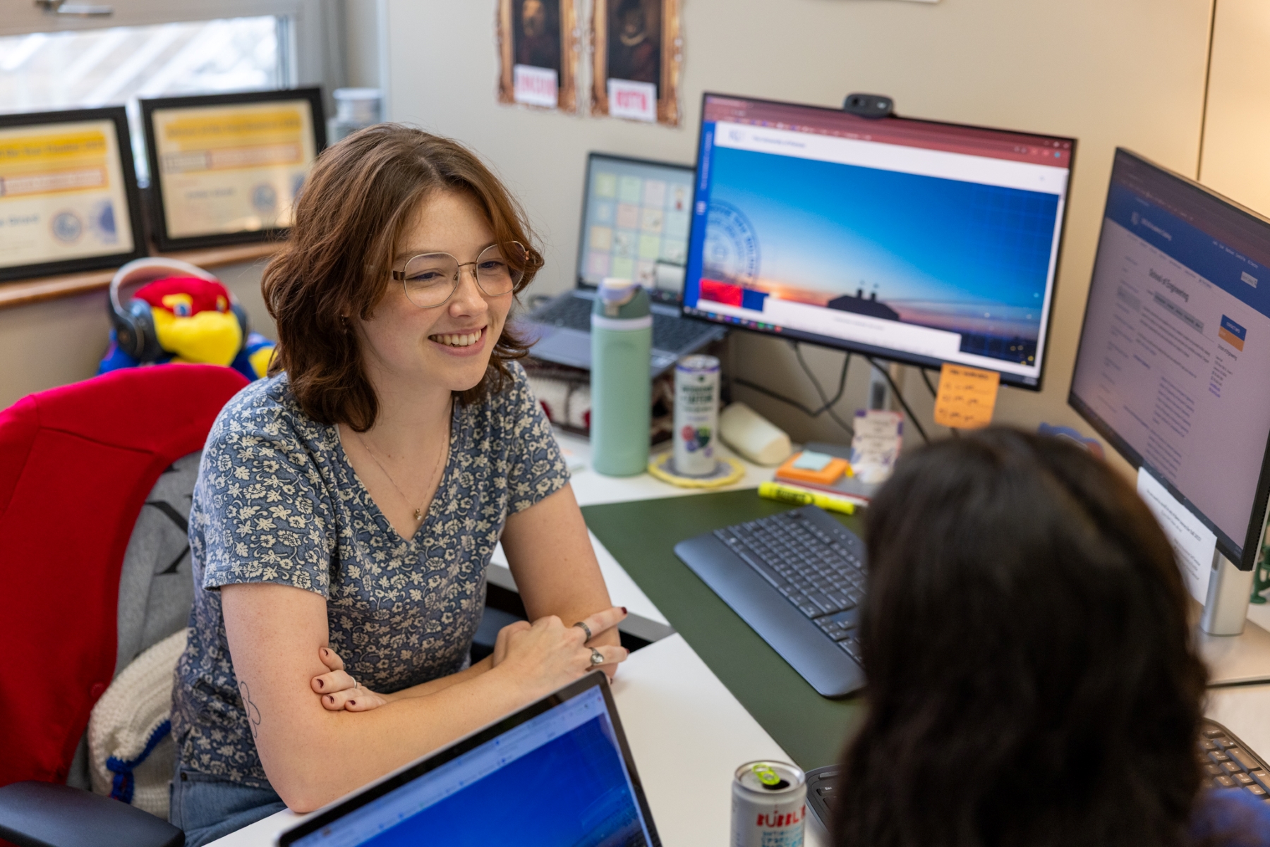 KU engineering advisor Emilee Girard chats with an engineering student across her desk.