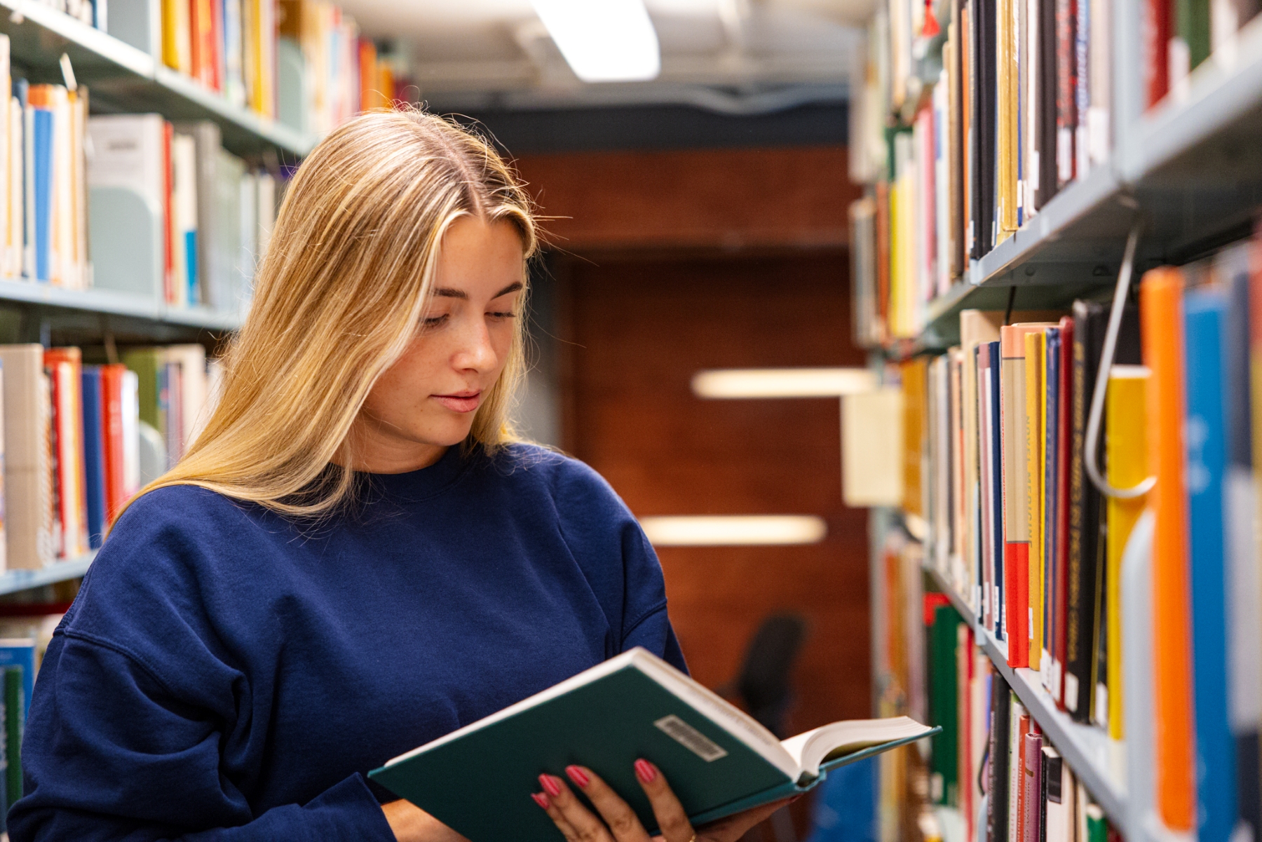KU student ambassador Audrey Inman in the stacks of Watson Library
