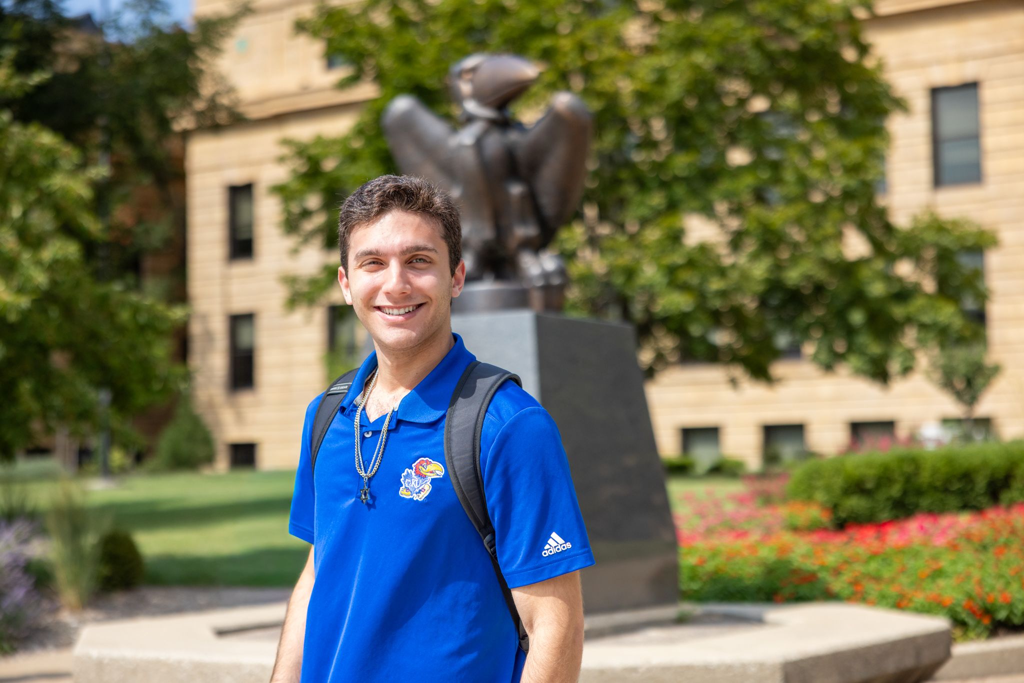 University of Kansas student Charles Lachman poses in front of the bronze Jayhawk statue at Strong Hall.