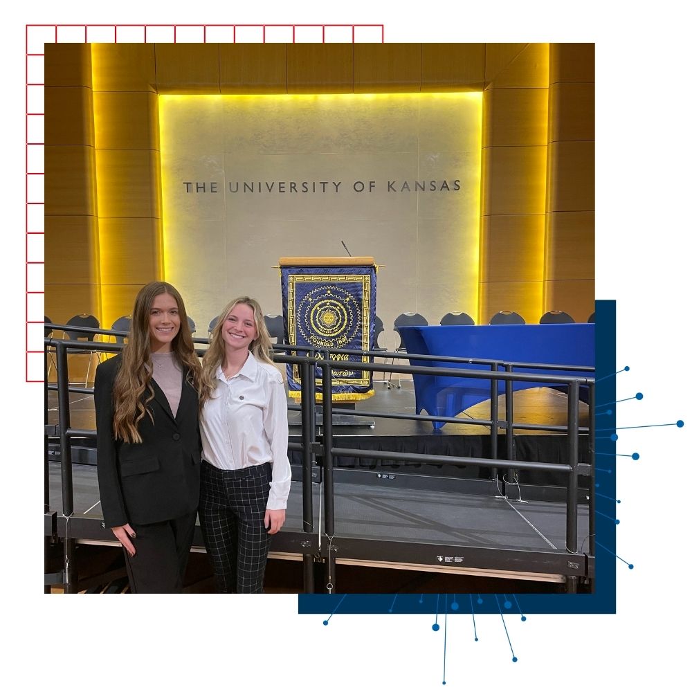 KU student Reagan Cherwin poses in front of a podium at a campus event.