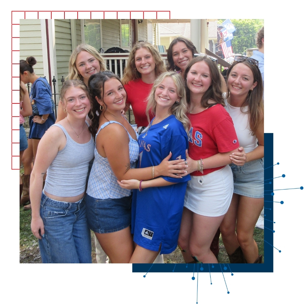 University of Kansas students pose in a group at a game day tailgate. 