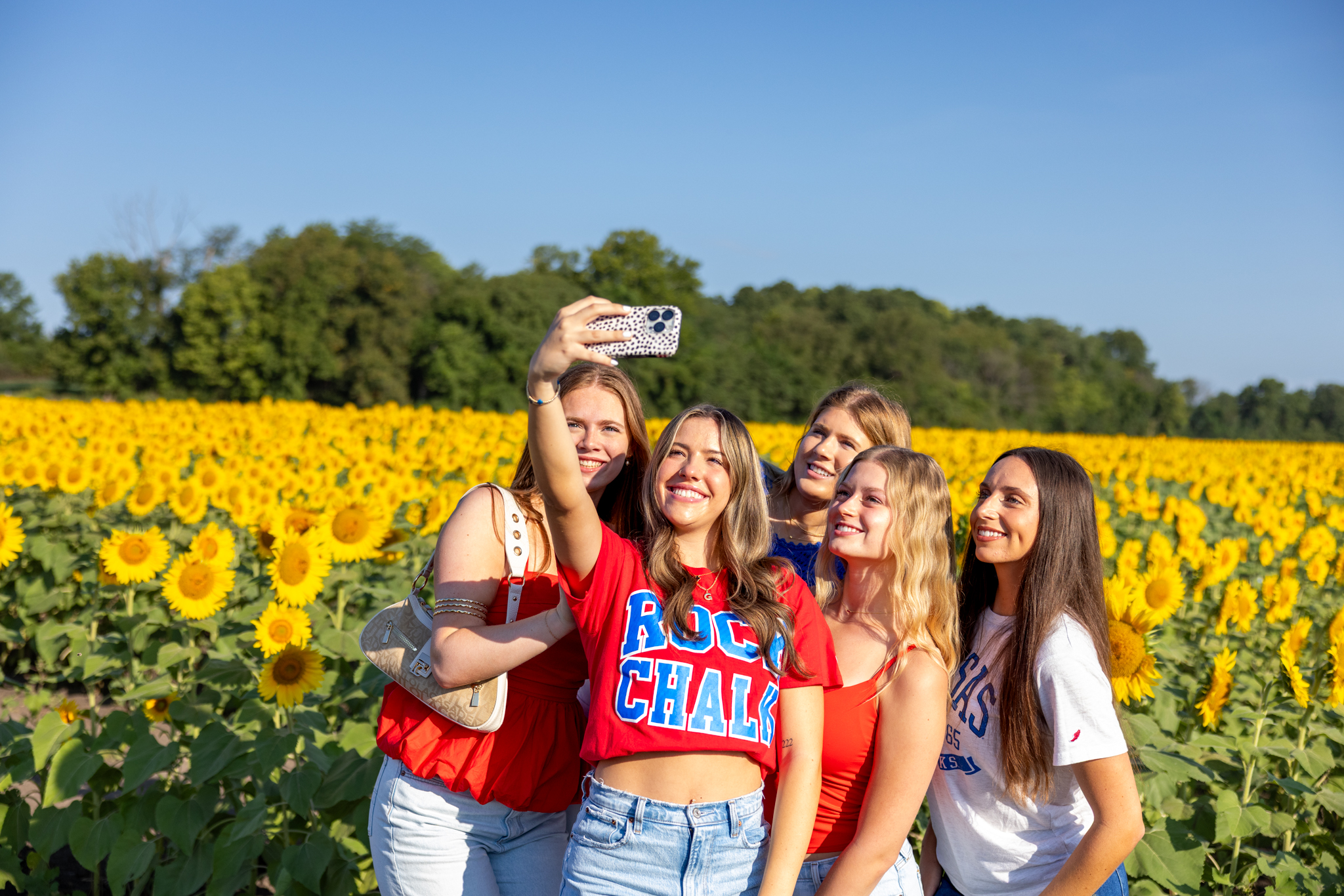 University of Kansas students pose for a selfie in a field of sunflowers in Lawrence, Kansas.