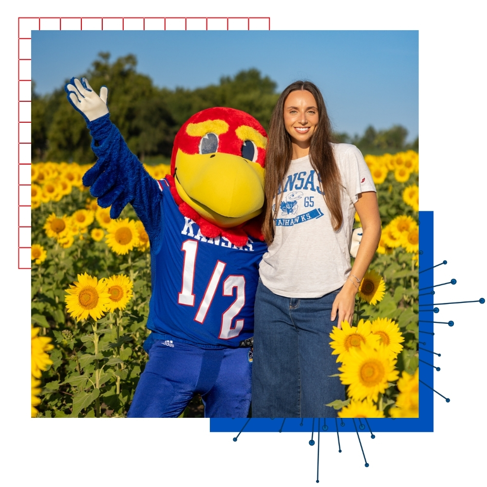 University of Kansas business student Sarah Forey poses with Baby Jay in a field of sunflowers.