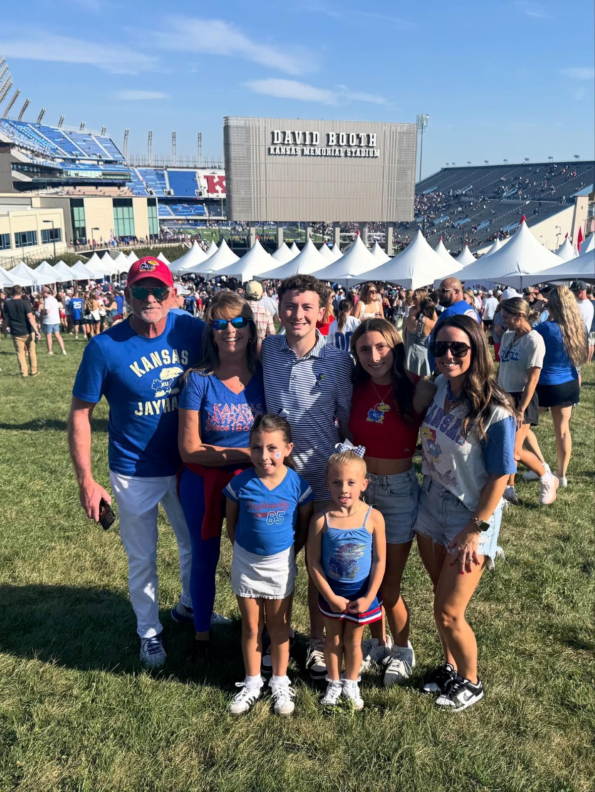 University of Kansas freshman Jaden Dallen and his family pose for a photo in front of the David Booth Kansas Memorial Stadium during KU Family Weekend.