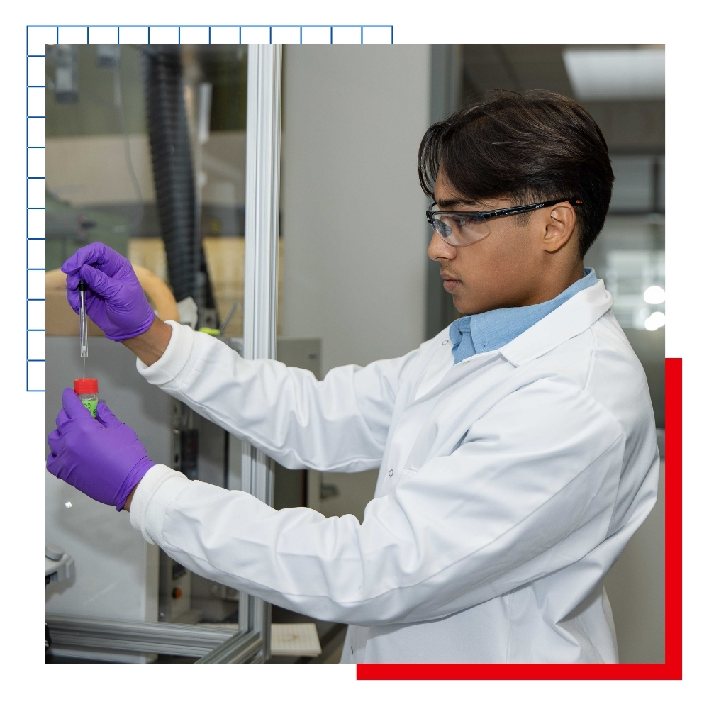 University of Kansas undergraduate researcher Pritam Ray looks at a test tube in a lab. 