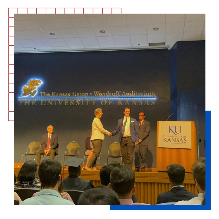 University of Kansas International Alumnus Bander Almohammadi’s KU Law shaking hands on the stage of Woodruff Auditorium