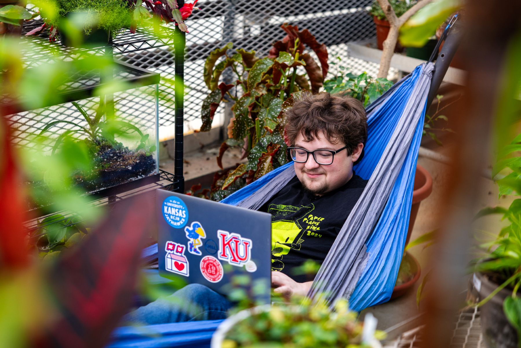 A KU student relaxes in a hammock inside Haworth Hall, a secret study space on campus