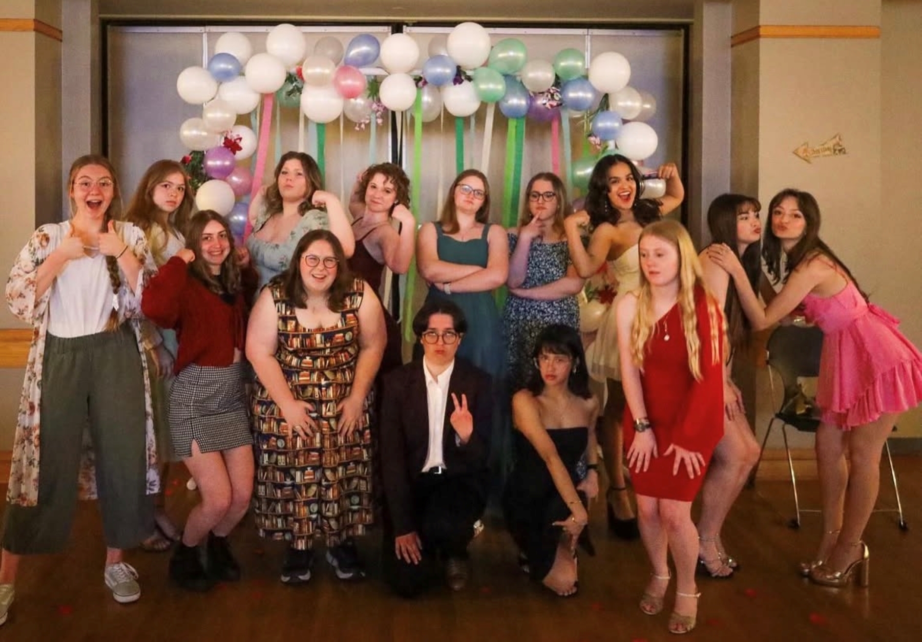 A group of KU students gathers for an event with a balloon backdrop.