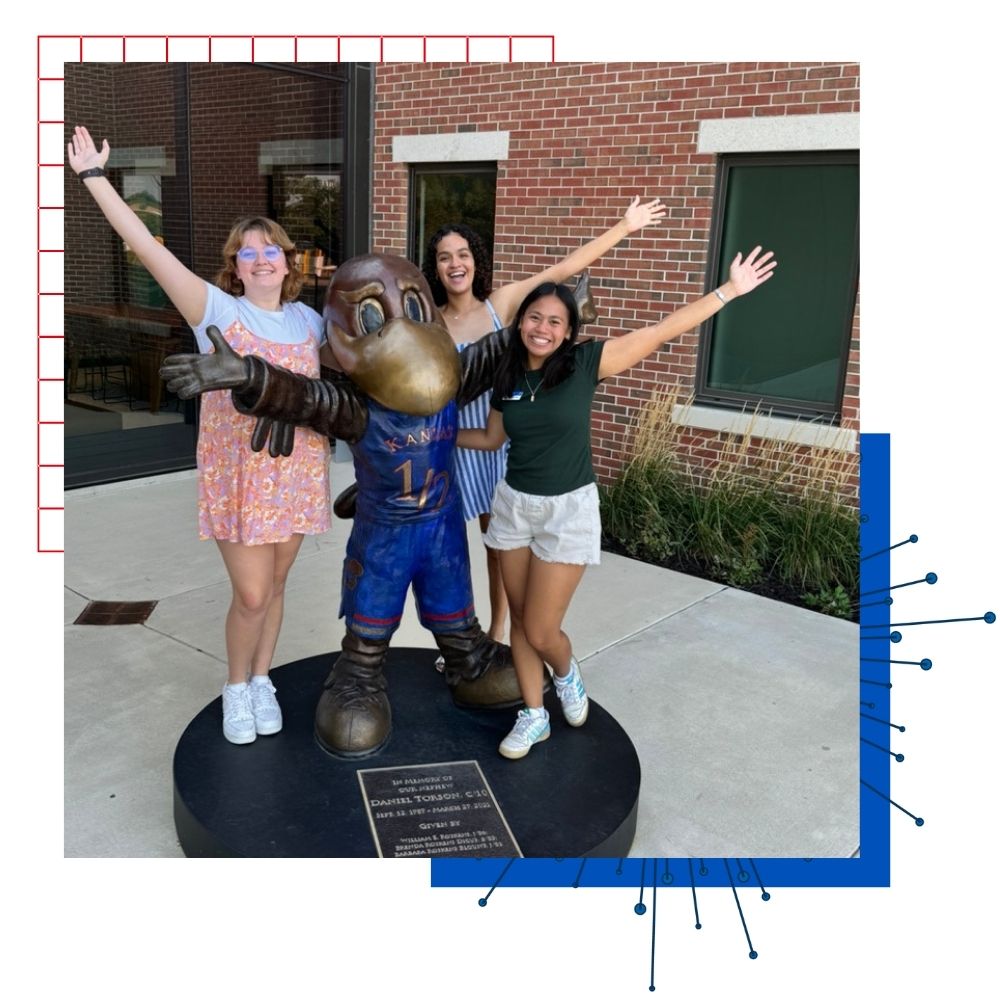 Ku students pose with a Baby Jay statue in front of the Jayhawk Welcome Center.