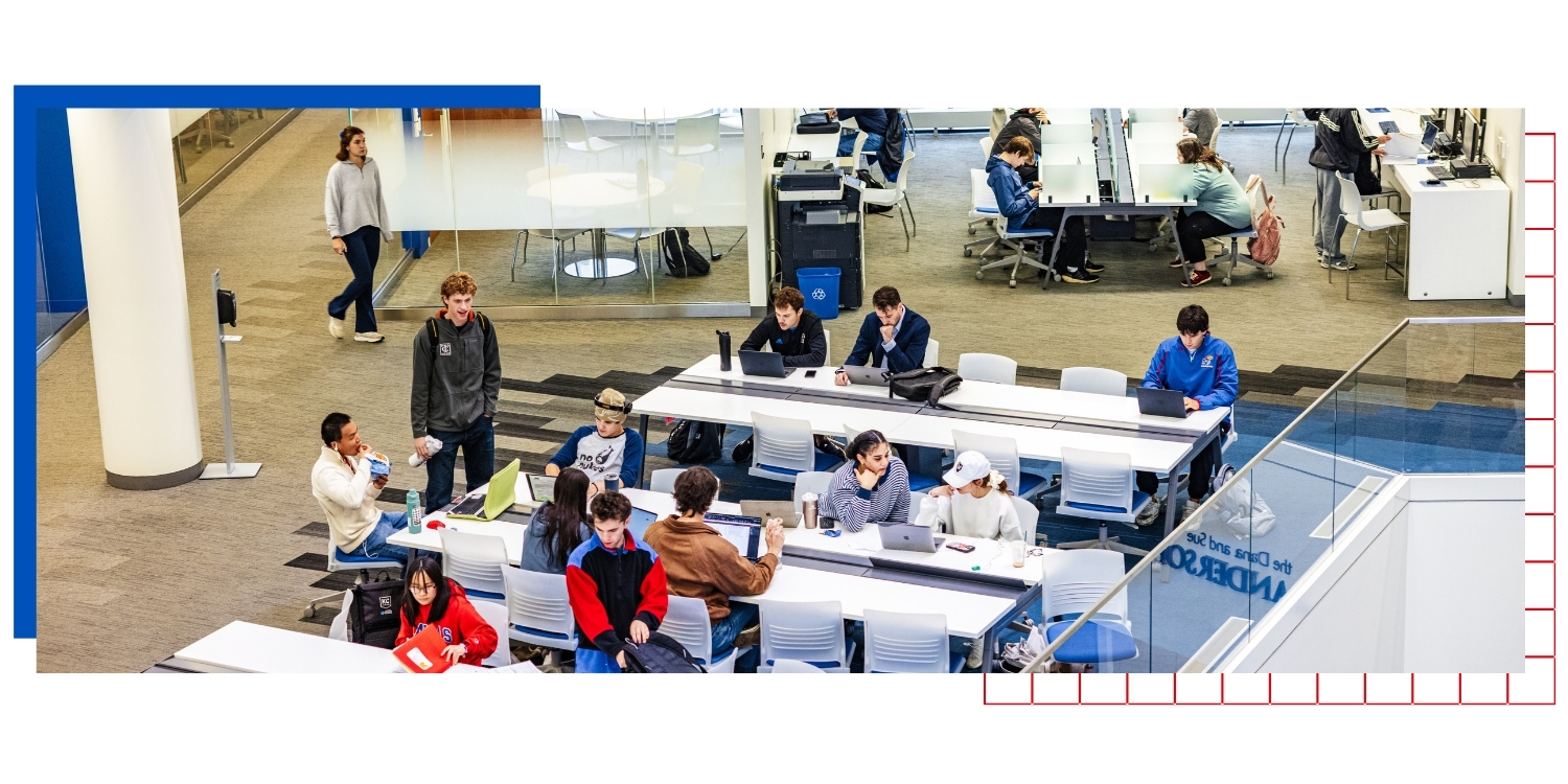 An overhead view of students studying at long white desks at the University of Kansas School of Business.