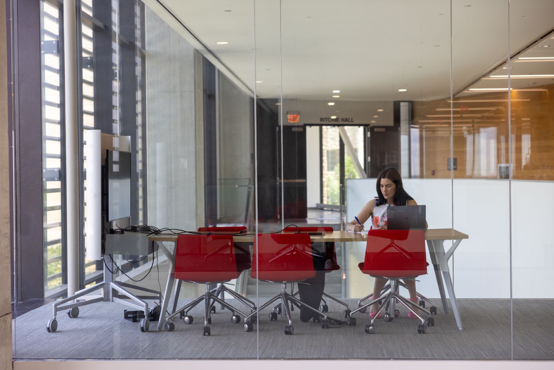 A University of Kansas graduate student works in a class conference table space on the KU campus.