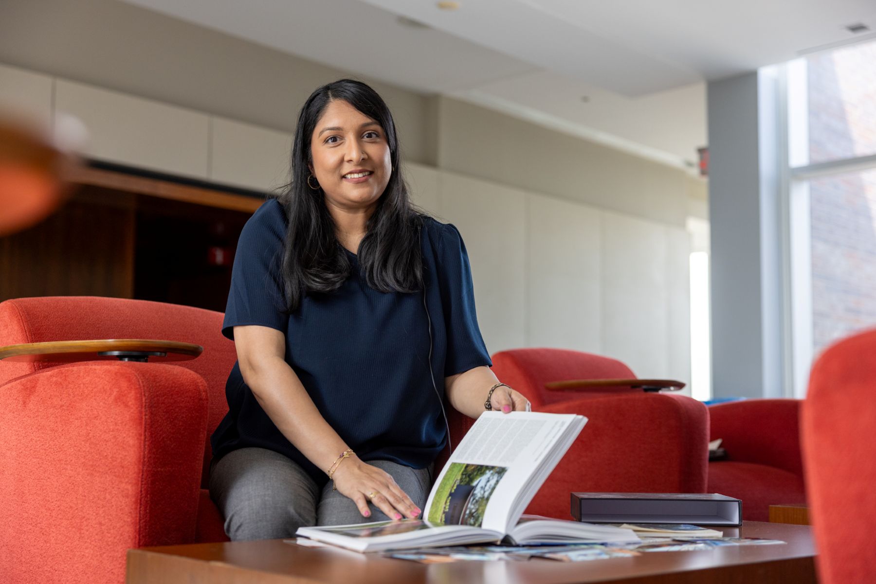 A University of Kansas alumna of the school of architecture, a KU professional degree program, browses through a book featuring her university portfolio.