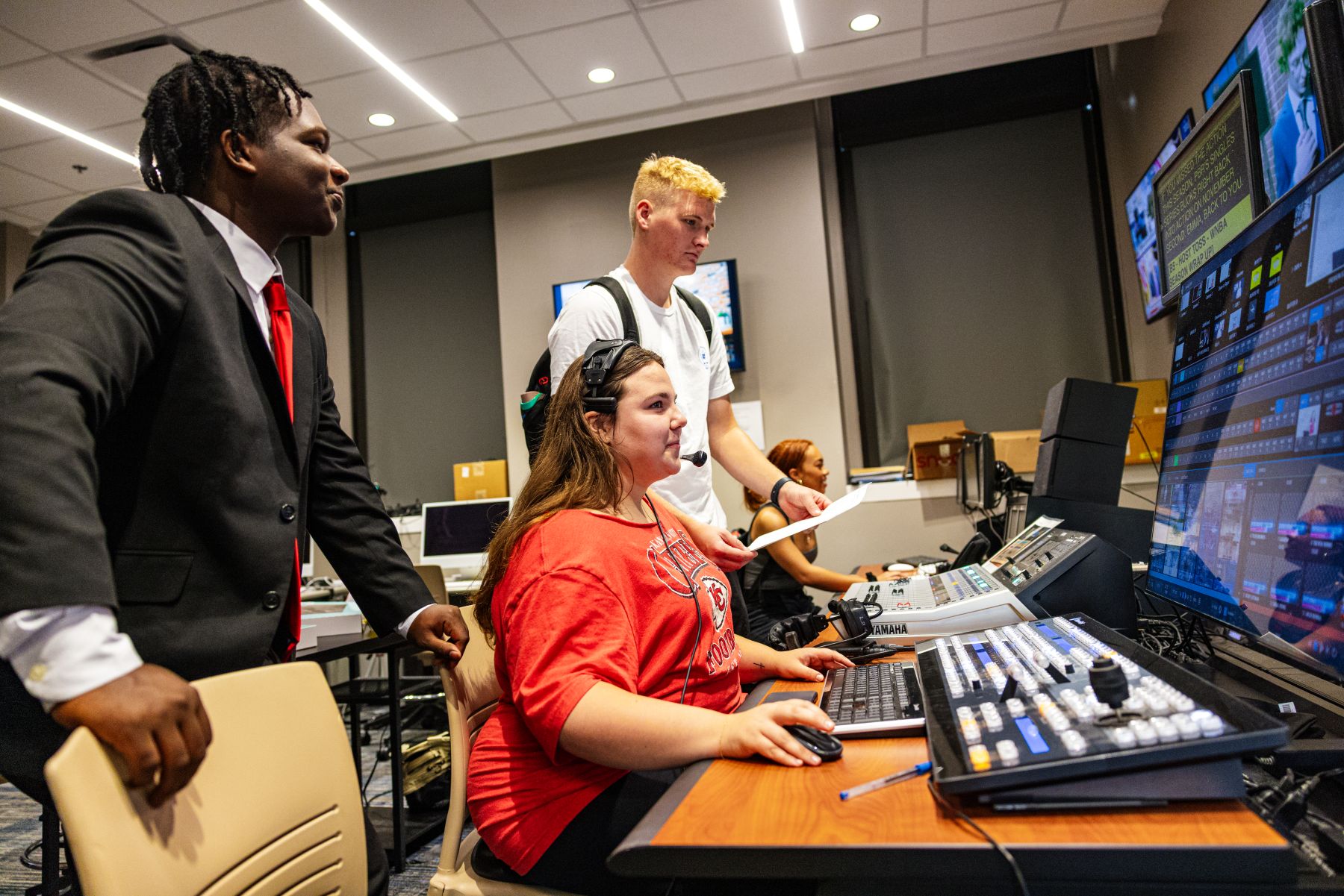 A group of KU students work behind the scenes in the William Allen White School of Journalism, filming a studio production.