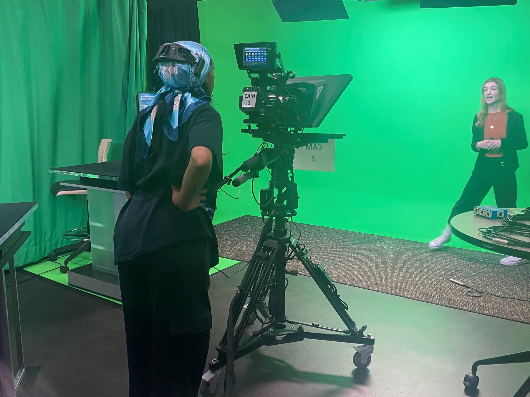 University of Kansas Indigenous Studies Master's student Lauryn Callis stands behind a camera in a film production studio.