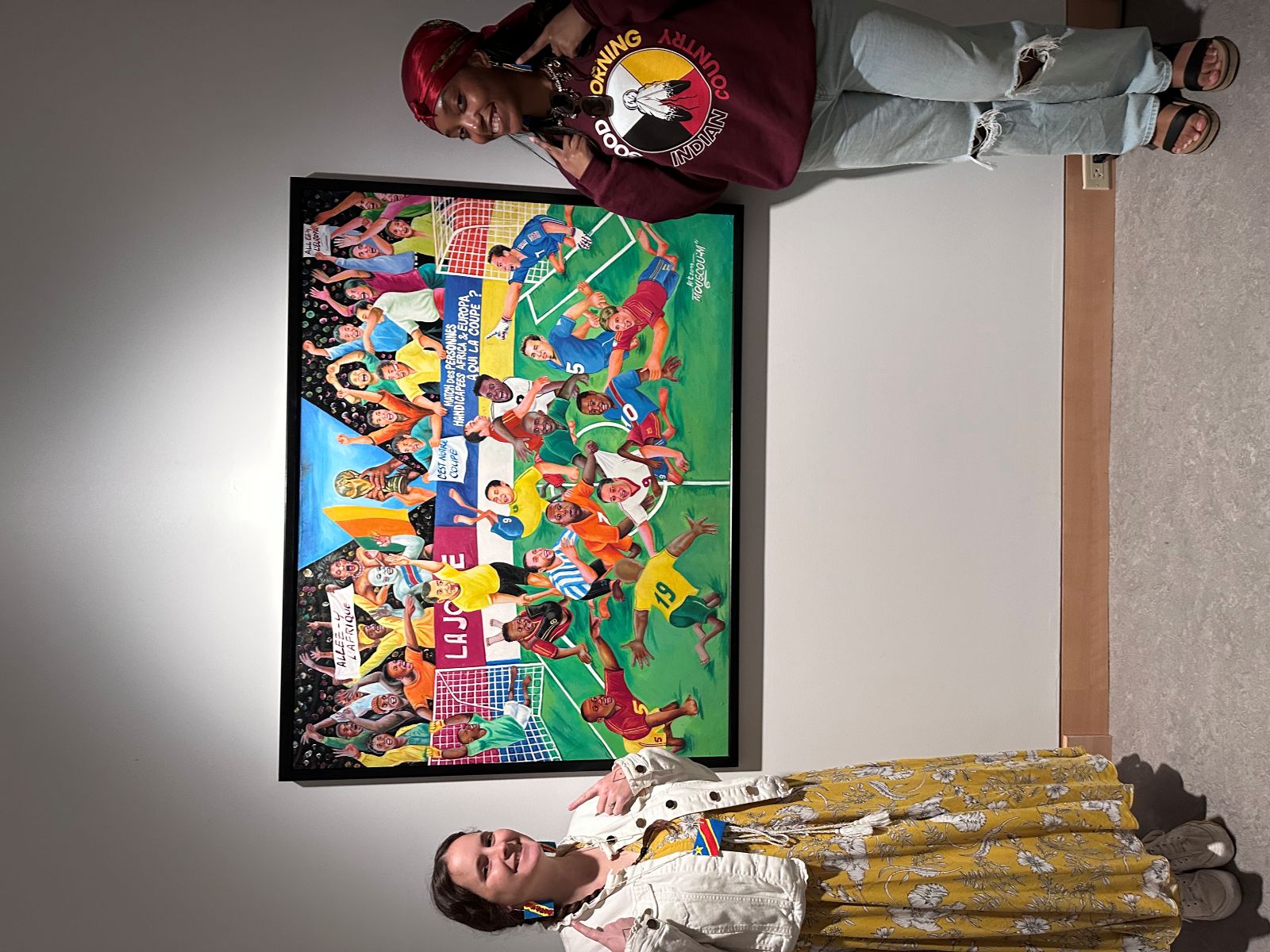 University of Kansas Indigenous Studies masters students stand with an art display on the KU campus.