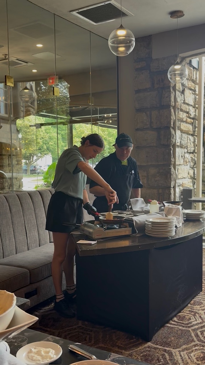 KU business administration student Ella Hayes serves food with a chef at the Elms Resort and Spa during her internship.