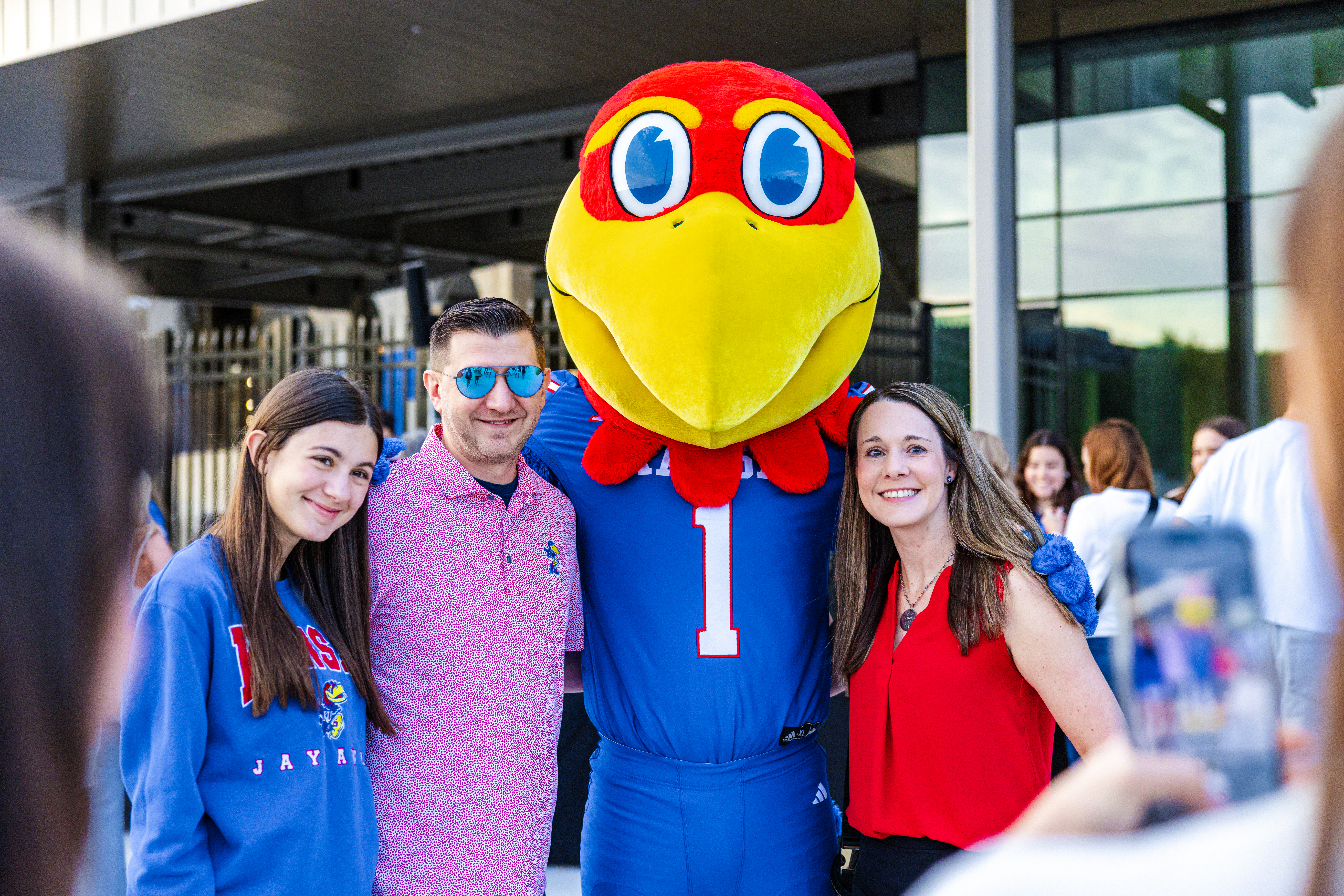 A KU family poses with the Jayhawk mascot
